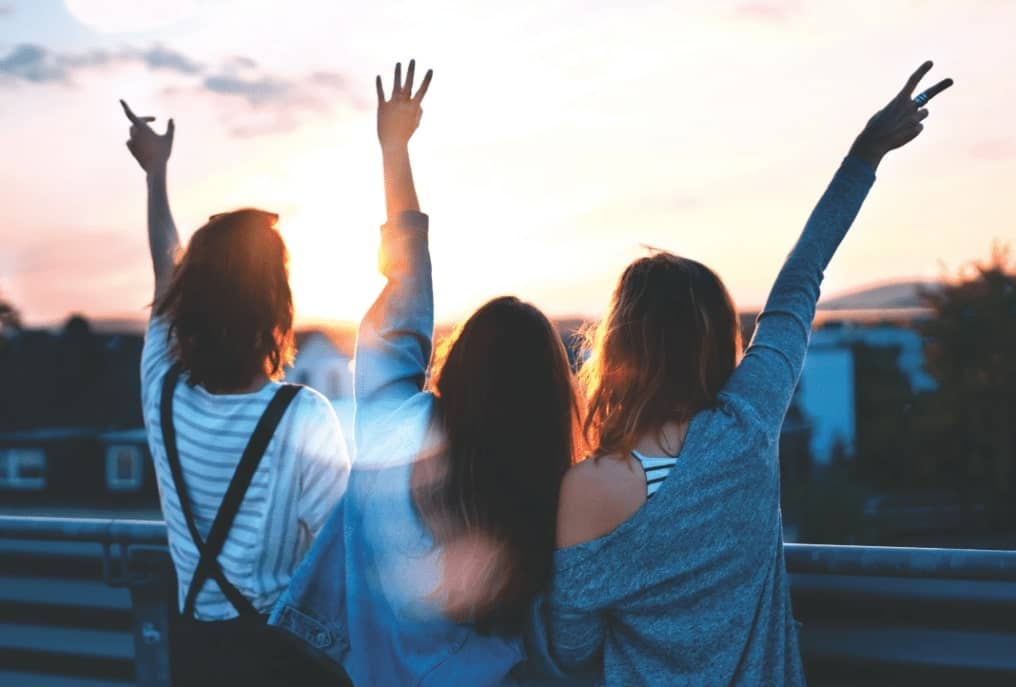 3 people enjoy a beautiful sunset